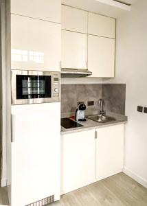 a white kitchen with a sink and a microwave at Zen Studio Apt Lekki 1 in Ilado