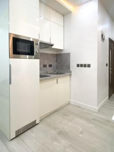a white kitchen with a sink and a refrigerator at Zen Studio Apt Lekki 1 in Ilado +11 photos
