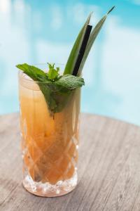 a drink in a glass on a wooden table at Bella Vista Hôtel, Suites & Maisons in Porticcio