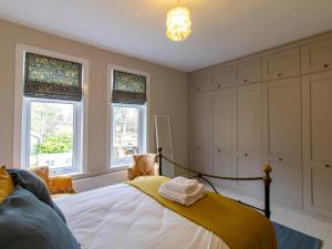a bedroom with a bed and two windows at Pass the Keys Charming Retreat – Perfect for Outdoor Lovers in Lanchester