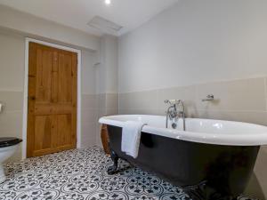 a bathroom with a black and white tub and a toilet at Pass the Keys Charming Retreat – Perfect for Outdoor Lovers in Lanchester +24 photos