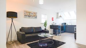 a living room with a couch and a table at Old Silk Apartments - Luxury Studios, 1 & 2-beds in Coventry City Centre by COVSTAYS in Coventry