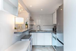 a kitchen with white cabinets and a sink at Monaco Seaview Border - 1bdr flat - 2beds - 4 guests in Beausoleil