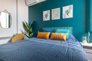 a blue bedroom with a bed with orange pillows at Monaco Seaview Border - 1bdr flat - 2beds - 4 guests in Beausoleil
