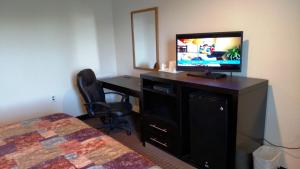 a hotel room with a television and a desk with a bed at Gene's Motel in Cinnaminson