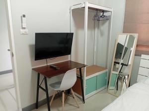 a bedroom with a desk with a television and a mirror at Harmony Heaven in Ban Yep Chaeng