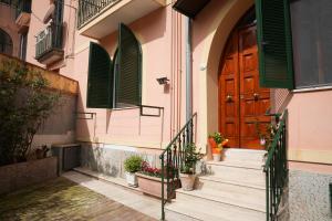 a building with a wooden door and stairs with potted plants at B&B Green Valley in Cava deʼ Tirreni