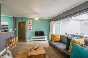 a living room with a couch and a tv at Seaside Apartment Perna Perna Umdloti by First Private Stays in Umdloti