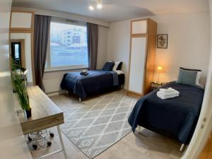 a hotel room with two beds and a window at Kaupunkikoti 3-room apartment A3 in Kemi