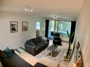 a living room with a couch and a chair at Kaupunkikoti 3-room apartment A3 in Kemi
