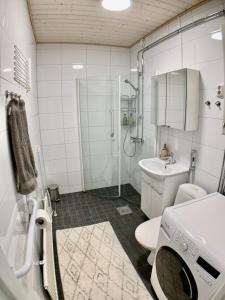 a bathroom with a shower and a toilet and a sink at Kaupunkikoti 3-room apartment A3 in Kemi +18 photos