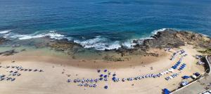 a group of people on a beach with umbrellas at COBAR0108 - Edifício Oceania in Salvador