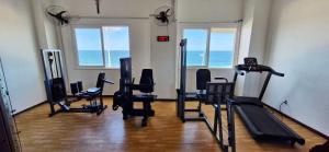 a gym with cardio equipment in a room with the ocean at COBAR0108 - Edifício Oceania in Salvador