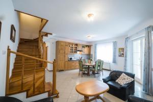a living room with a staircase and a table at Győrfi Apartmanház Zamárdi in Zamárdi