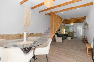 a dining room with a glass table and white chairs at Casa Woopi Torrevieja in Torrevieja
