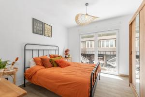 a bedroom with a bed with an orange blanket at Casa Woopi Torrevieja in Torrevieja