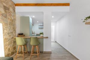 a kitchen with two green chairs and a counter at Casa Woopi Torrevieja in Torrevieja +18 photos