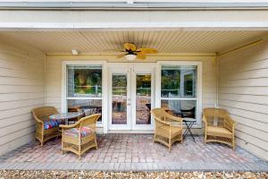 a patio with wicker chairs and a table and a ceiling fan at ‘Lakeside Getaway’ w/ Patio on Lady Bird Lake in Austin