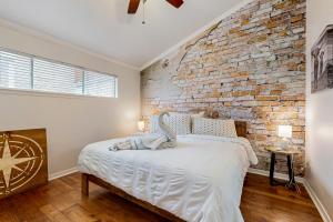 a bedroom with a brick wall and a bed at ‘Lakeside Getaway’ w/ Patio on Lady Bird Lake in Austin