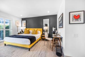 a bedroom with a bed and a desk with a chair at Fairway Sleek Chic in Palm Springs