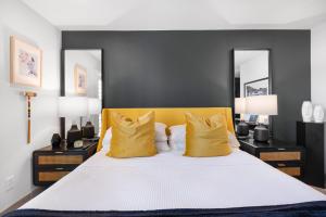 a bedroom with a large bed with yellow pillows at Fairway Sleek Chic in Palm Springs