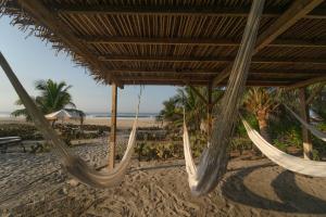 a couple of hammocks on a beach at Cabanas Adobe Frente Al Mar in Puerto Escondido