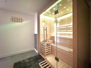 a walkin shower with a glass door in a room at La sernhacoise, Maison familiale rénovée, sauna in Sernhac
