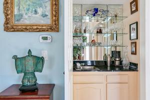 Una habitación con un lavabo y un estante con vasos. en Fairways Mtn Views, en Palm Springs