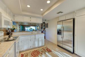 a large kitchen with white cabinets and a refrigerator at Villas de Las Flores Serena in Palm Springs
