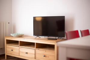 a television sitting on top of a wooden entertainment center at Capo Bianco Terrace - Helloelba in Portoferraio