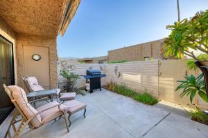 a patio with two chairs and a table and a grill at Villas de Las Flores Serena in Palm Springs +10 photos