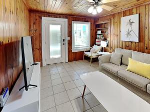 a living room with a couch and a tv at Sea Glass Suites 2 in Topsail Beach