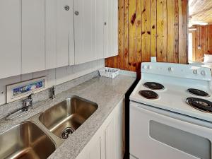 a kitchen with a sink and a stove at Sea Glass Suites 3 in Topsail Beach +7 photos