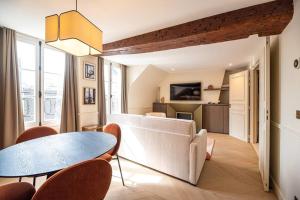 a living room with a table and chairs at vivez au coeur du Marais in Paris