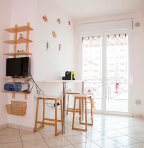 eine Küche mit Tisch und Stühlen und einem Fernseher in der Unterkunft Casa Anna in Marina di Montenero