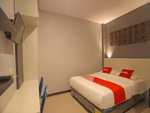a bedroom with a bed with red pillows on it at Capital O 92096 Kuala Ulee Lheue Residence Syariah in Banda Aceh
