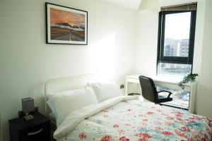 ein Schlafzimmer mit einem Bett und einem Stuhl und einem Bild an der Wand in der Unterkunft Opulent Apartment City Centre in Sheffield