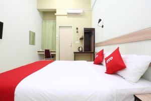 a bedroom with a large white bed with red pillows at Hotel O Green Mango @ Sri Cemerlang in Kota Bharu +23 photos