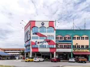a building with cars parked in a parking lot at Hotel O 340 Comfort Hotel in Kampong Batu Belah +37 photos