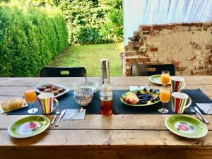 a wooden table with plates of food and glasses of orange juice at Relax in Borgosesia