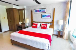 a bedroom with a large bed with two red pillows at OYO 394 Nana Beach Cha Am in Cha Am