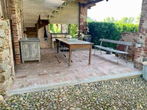 a patio with a table and a stove and a bench at Relax in Borgosesia +26 photos