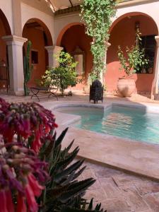 a courtyard with a swimming pool in a building with flowers at RIAD CHANT D'ETOILES tadighoust in El Hara