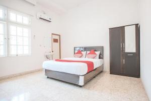 a bedroom with a large bed with red and white pillows at Capital O 332 Residence G17 Kemang in Jakarta