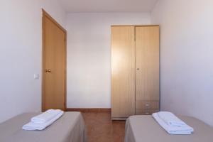 a bedroom with two beds and a cabinet with towels at Rentalmar Brisas in Miami Platja +45 photos