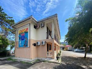 a small building with a sign on the side of it at Capital O 91094 Hotel & Chalet Sportfishing in Batu Ferringhi