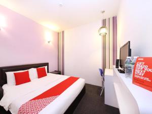 a hotel room with a red and white bed and a desk at Hotel O Marvelton Hotel in Butterworth