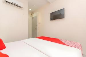 a white room with a bed and a flat screen tv at Skudai Hotel in Skudai