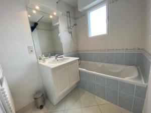 a bathroom with a sink and a tub and a mirror at Fouesnant Beg Meil, duplex au coeur du village, à 450 m de la plage in Beg-Meil +17 photos