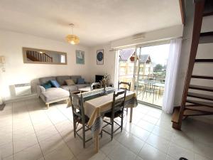 a living room with a table and a couch at Fouesnant Beg Meil, duplex au coeur du village, à 450 m de la plage in Beg-Meil